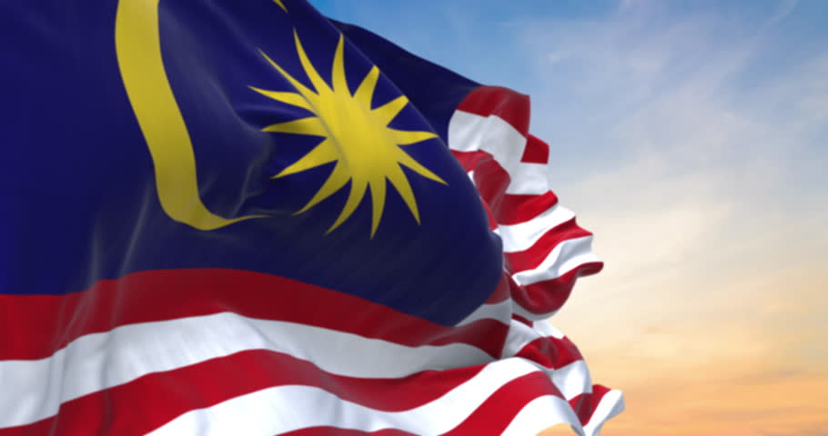 Detailed close up of the national flag of Malaysia waving in the wind on a sundown, seamless loop and slow motion animation