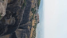 Vertical video. Meteora, Kalabaka, Greece. Monastery of St. Stephan. Meteora - rocks, up to 600 meters high. There are 6 active Greek Orthodox monasteries listed on the UNESCO list, Aerial View