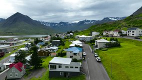 Traditional village in Iceland among picturesque mountains. Summer in Iceland. Flying a drone over the city. Scenic view. A small town in the north of Iceland.