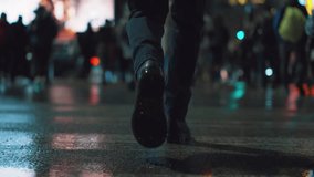 Rear back view male feet steps crossing busy street at night. Man wearing dark leather boots goes on pedestrian crossing in city. Low angle people crowd legs walking sidewalk, rainy autumn weather - Powered by Shutterstock - Get 15% off with code: PIKWIZARD15