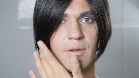 Travesty make up. a young man makes himself a transsexual mencup. 4k, slow motion.