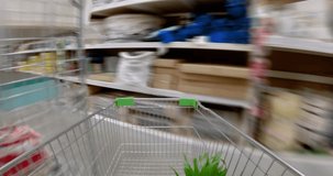 Construction hypermarket. Megamall of goods for home and construction. Narrow high aisles. A customer rolls a cart. Special effect. Hyperlapse loop POV video