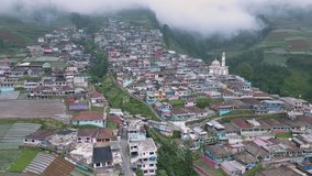 Drone flies over a rural house built in steps on a mountainside. Aerial view of Nepal Van Java village on the slope of Mount.Sumbing, Indonesia