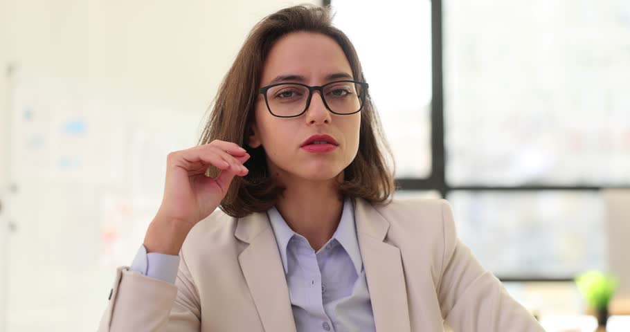Brunette woman removes glasses perplexed by unexpected turn of events. Businesswoman with furrowed brow unable to comprehend unexpected news Royalty-Free Stock Footage #3436990861