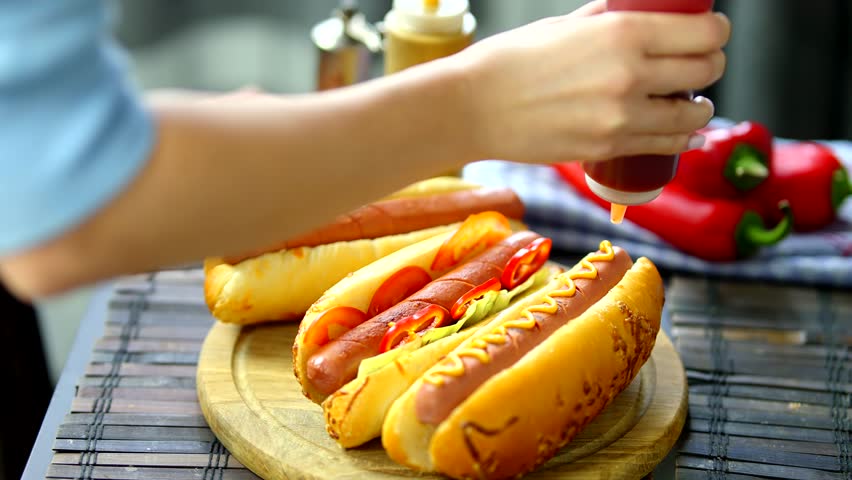 HotDog Served Mustard And Ketchup. Tasty American Fast Food. Tasty HotDog With Grilled Sausage. Appetizing Street Food.Grilled Sausage HotDog Junk Food. Adding Ketchup And Mustard To Tasty HotDog Meat Royalty-Free Stock Footage #3437115063