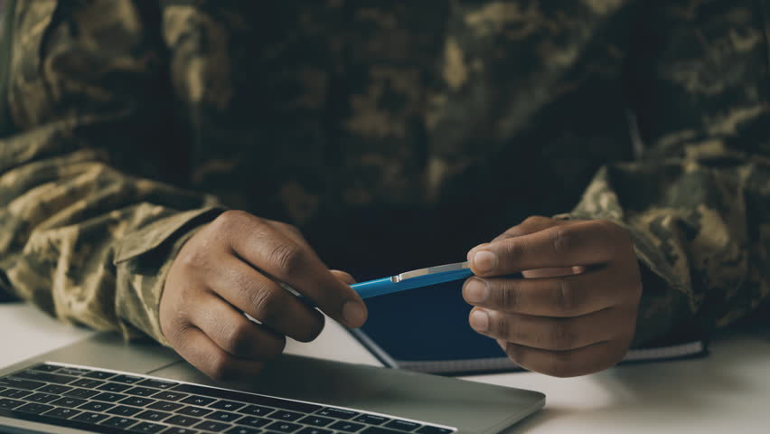 Close-up hands of army general holding pen, planning national defense strategy