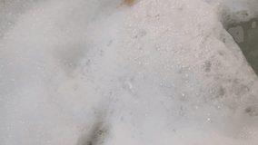 Close-up thick foam at bath tub. POV taking a bath. Macro texture of soap bubbles. Bath time. Fun bathing at home. Feet and rubber ducks. Film grain pixel texture. Soft focus. Blur. Live camera - Powered by Shutterstock - Get 15% off with code: PIKWIZARD15