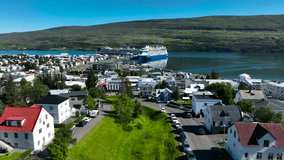 A cruise ship docks in the port of Akureyri in Iceland. Cruise on the Atlantic Ocean. Port in Iceland. Akureyri City in Iceland