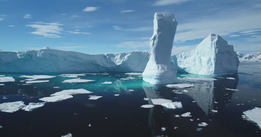 Towering melting iceberg global warming concept. Snow covered glacier float turquoise ocean water in sunny summer day. Polar climate change issue. Wild Antarctica nature environment. Close up panorama