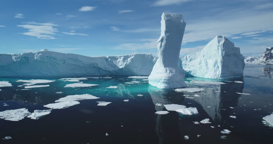 Towering melting iceberg global warming concept. Snow covered glacier float turquoise ocean water in sunny summer day. Polar climate change issue. Wild Antarctica nature environment. Close up panorama
