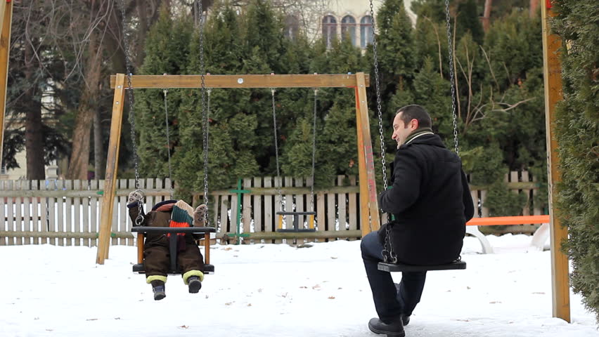 Baby enjoying time with his father in park during a winter day