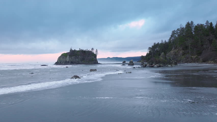 Aerial of cinematic Olympic National Park. Dramatic sea stacks on rocky Ruby Beach along the Olympic coastline on moody overcast evening. Ruby Beach on West Coast of Northern America. Washington State