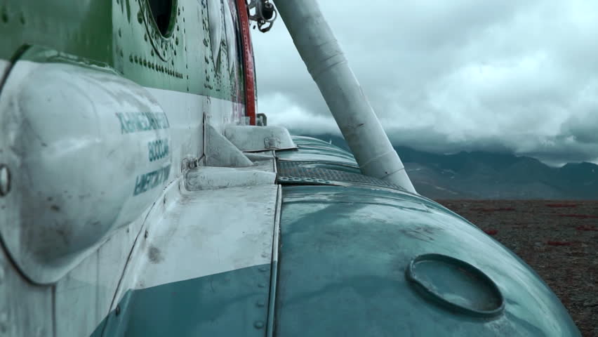 Close up of old rusty airplane on a hill top. Clip. Aircraft exterior details with heavy clouds and mountains on the background. Royalty-Free Stock Footage #3437399155