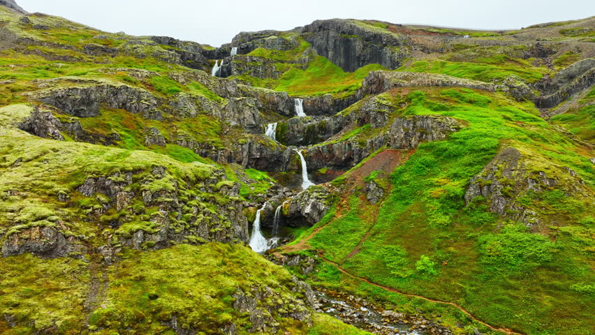 Waterfalls in mountain, Beautiful aerial view from Iceland in summer season, Icelandic highlands, Wild river with crystal clear cold glacial water, Water flows over the stones overgrown with moss