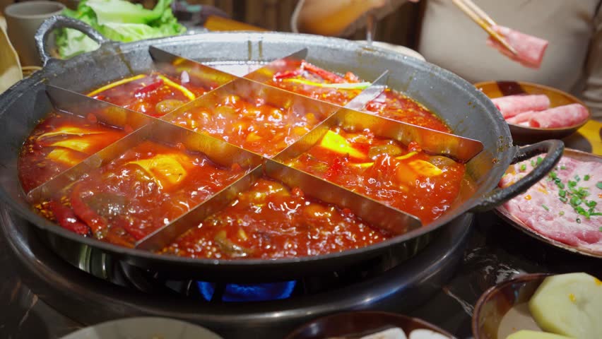 Female tourist eating original mala spicy hot pot in Chongqing, China