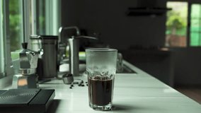 Video of an aromatic black coffee maker in a mug placed on a bar in a home kitchen.