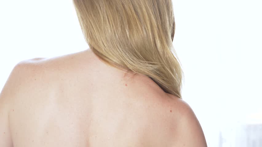 view from behind Beautiful woman with naked back, hair styling. Slow motion. calm attractive girl with long healthy hair. Close it. 4k