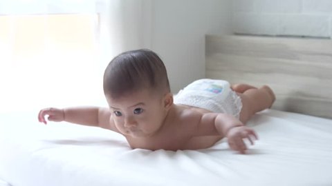 Head steady when held, Head up 45, prone, hands open half of time and using the abdominal support, Baby development stages of 5 month old concept, Slow motion