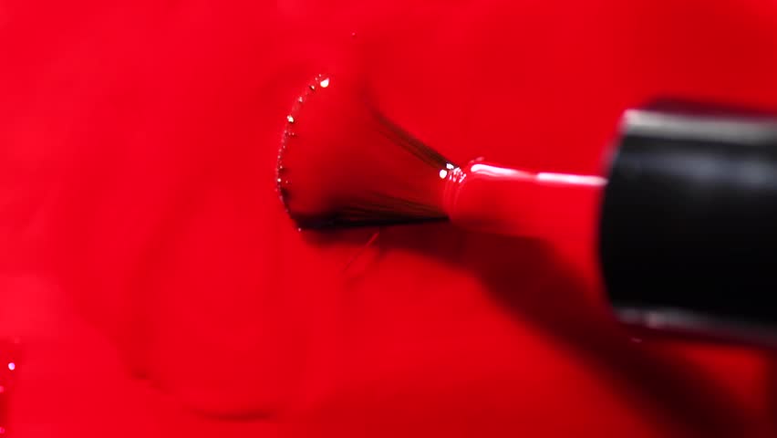 Red nail polish drops, manicure concept. Spilled uv gel, enamel, varnish with brush on red color background, splash. Beauty salon, nail care product. Nail art. Top view, fashion backdrop  Royalty-Free Stock Footage #3437732127