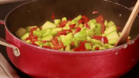 sizzling delight: sauté bell peppers and zucchini in a pan close-up