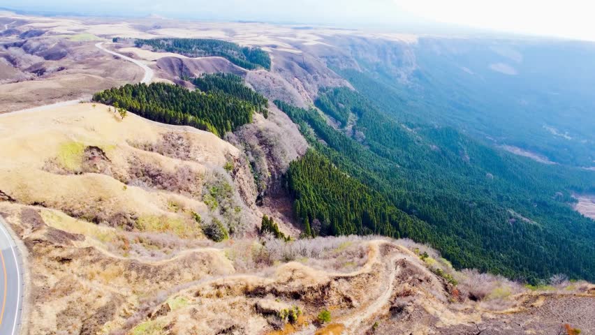 drone video capturing the majestic expanse of the Aso Caldera, one of the largest calderas in the world, located in the heart of Kumamoto Prefecture, Kyushu, Japan. 