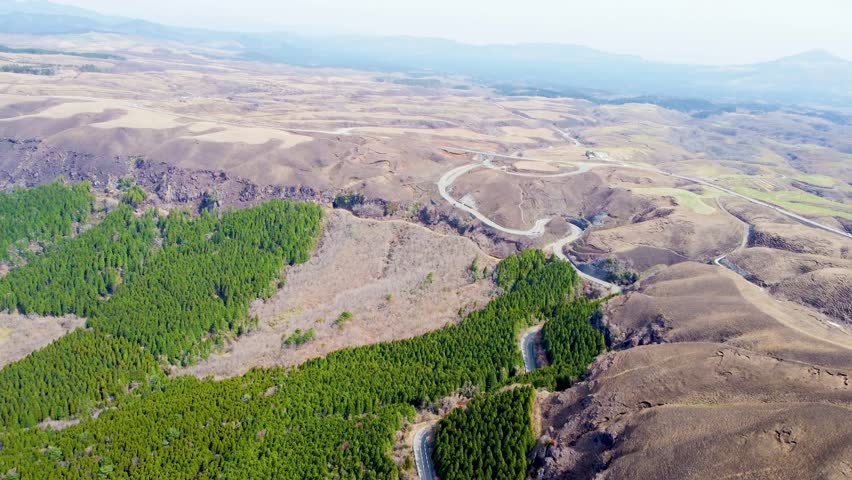 drone video capturing the majestic expanse of the Aso Caldera, one of the largest calderas in the world, located in the heart of Kumamoto Prefecture, Kyushu, Japan. 