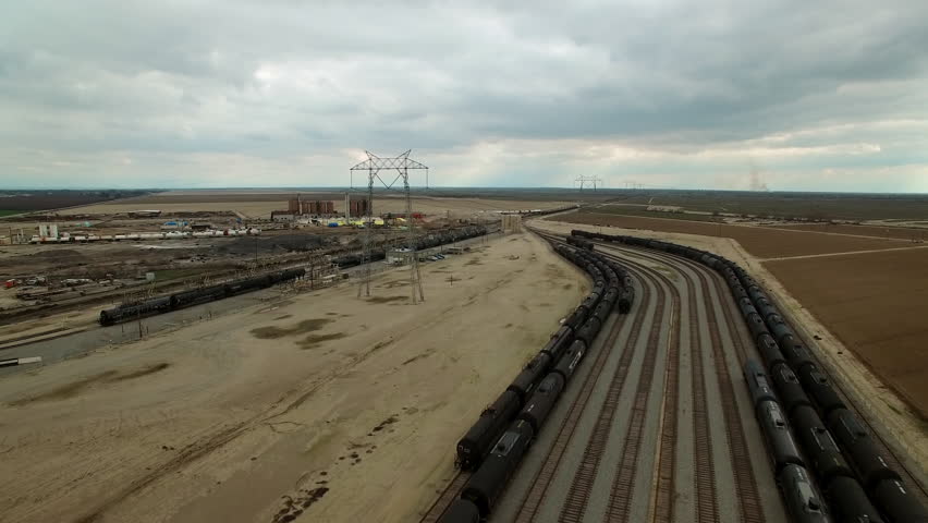 Aerial Forward Shot Of Transmission Tower By Tranquil Shunting Yard Under Cloudy Sky - Bakersfield, California