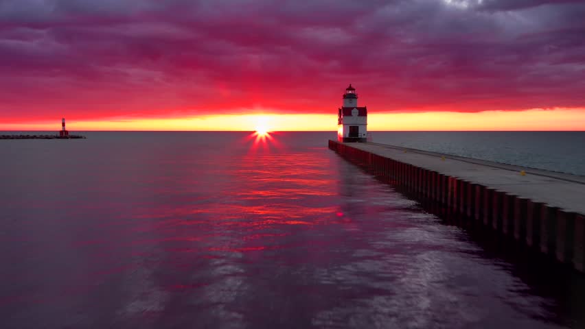 Mesmerizing aerial view of Winter sunrise over scenic Lake Michigan harbor and lighthouse.