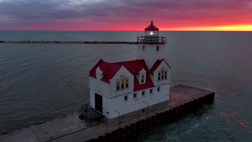 Mesmerizing aerial view of Winter sunrise over scenic Lake Michigan harbor and lighthouse.