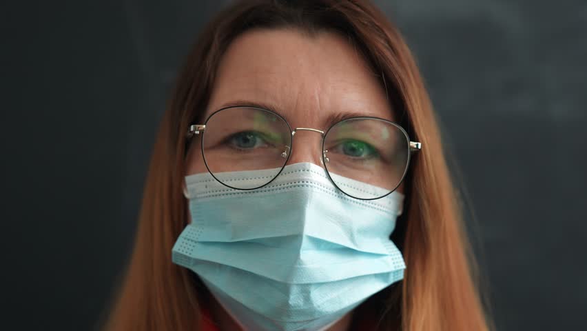 Happy family concept.close up of girls face in medical mask.woman looks at camera.face mask protects against virus.girl at home wearing medical mask.protection of respiratory tract from infection Royalty-Free Stock Footage #3437886843