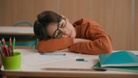 Tired Caucasian exhausted sad upset fatigued little child boy kid son pupil schoolboy in glasses primary class schoolchild lying on table desk in school lesson difficult sleepy homework boring study - Powered by Shutterstock - Get 15% off with code: PIKWIZARD15