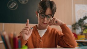 Caucasian guy boy think find idea ponder difficult task writing notes math exercise class lesson school learn write copybook kid schoolboy child pupil thinking studying primary education rise finger - Powered by Shutterstock - Get 15% off with code: PIKWIZARD15