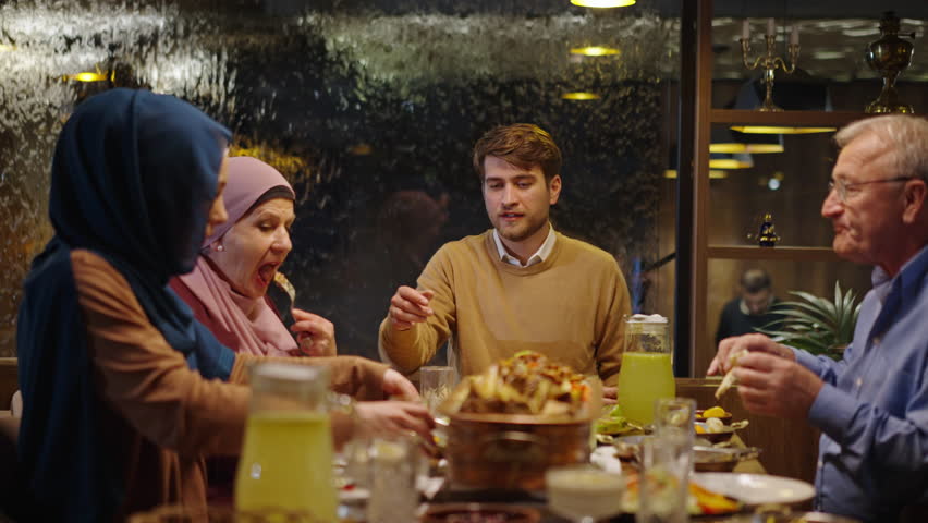 Happy Muslim Family Enjoying the Fast Breaking Meal at the Restaurant in Ramadan. Multigenerational Relatives Eat Eid Meal Royalty-Free Stock Footage #3437939027