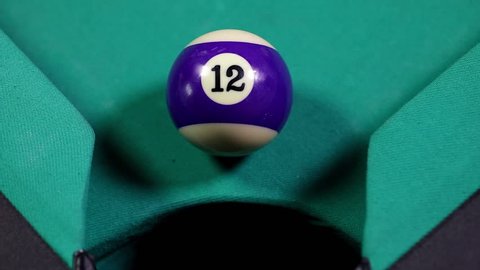 Close up of a snooker ball number 12 with purple color get into billiard pocket