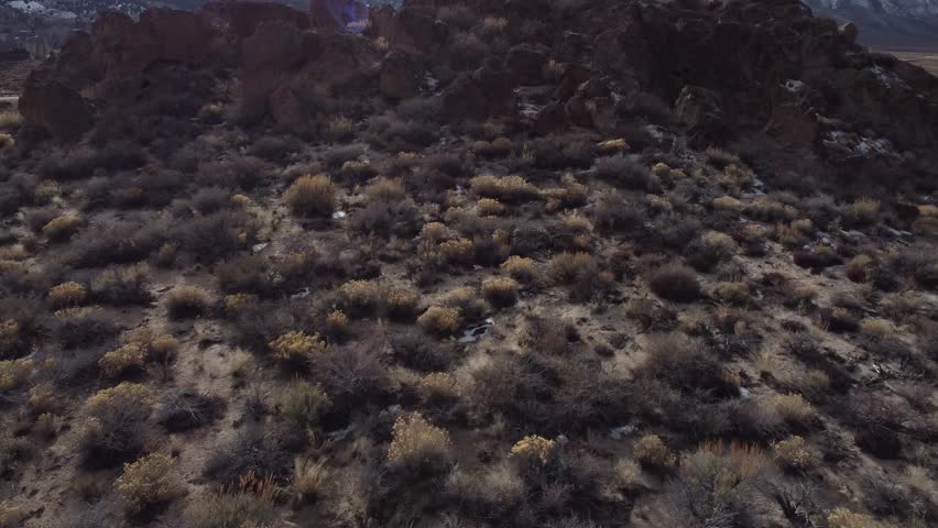 Snow Capped Mountains Drone Reveal in Sierra Nevada Mammoth Mountains Range next to Desert Highway with cars driving by