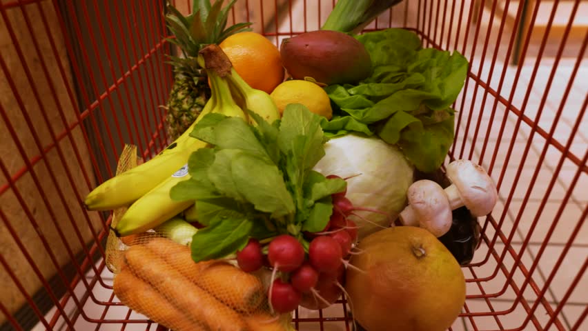View from Shopping Trolley, the process of buying products in a store, the basket is filled with vegetables and fruits. Time lapse