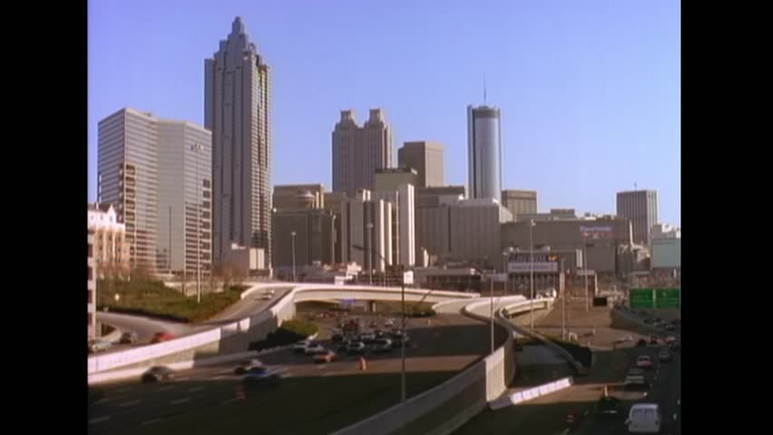 Atlanta - 1995 - aerial view of traffic driving by the atlanta, georgia skyline including the westin peachtree plaza hotel, truist plaza, and 191 peachtree tower.