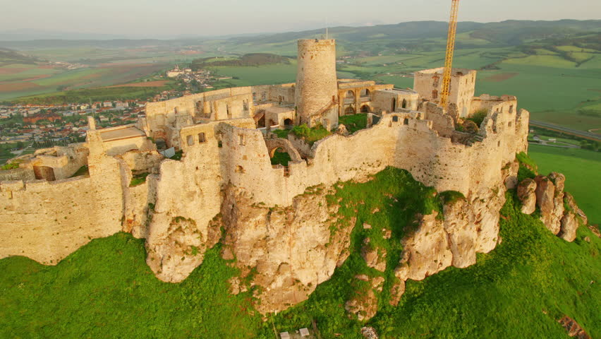 Aerial view of the Spis castle at sunrise, Unesco World Heritage Site, Slovakia. Spissky hrad medieval castle. Spis Castle in the town of Spisske Podhradie in Slovakia. Drone orbit shot
