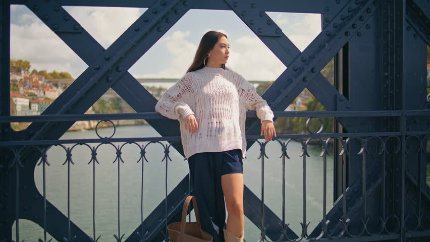 Confident woman leaning iron fence construction at summer vacation zoom on. Relaxed latina girl looking distance enjoying wind at sunshine closeup. Young beautiful lady standing bridge. Tourist life