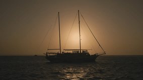 Large sailing ship yacht on the sea on a sunset. The old tourist ship gracefully sails in the open sea. Lifetime adventure cruise. Luxury travel experience. Golden picturesque sunset at background. - Powered by Shutterstock - Get 15% off with code: PIKWIZARD15