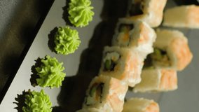 Vertical video. Sushi set. Rolls eating. Human hand picking up asian meal japanese cuisine tasty delicious dish in restaurant.