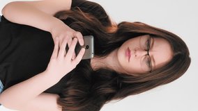 Vertical video. Mobile conflict. Angry chat. Annoyed dissatisfied woman arguing texting message using phone app isolated on white.