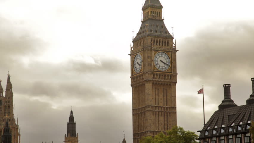 Big Ben tower with white storm clouds behind it in London, England.