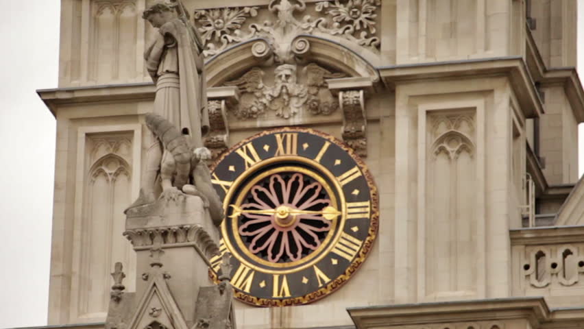 Tower clock of Westminster Abbey with St. George column in foreground.