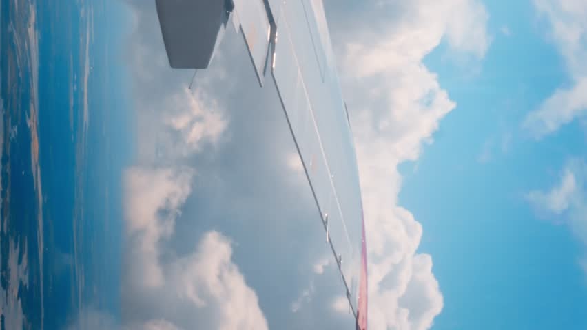 View from airplane window beauty aviation sky's expanse vertical video View from airplane window passengers witness marvels flight. View from airplane window presents awe-inspiring view heavens. Royalty-Free Stock Footage #3438418559
