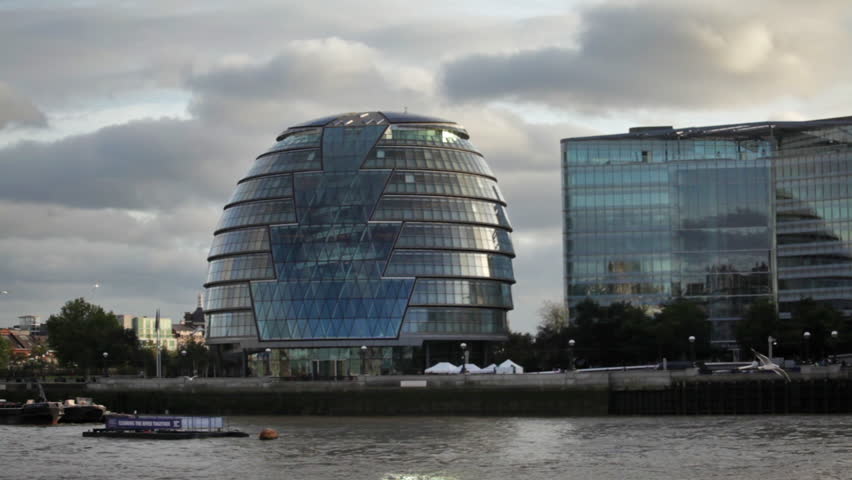 City hall building from across River Thames, with birds flying over water in