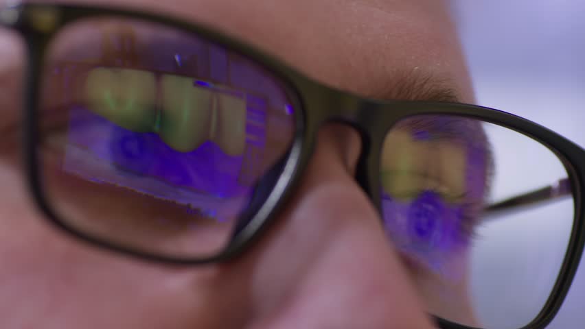 The reflection in the man's glasses of the monitor with the artificial jaw simulation program. Royalty-Free Stock Footage #3438486703