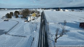 Snowy American countryside in winter. Aerial shot above rural road in USA with farmland covered in snow. - Powered by Shutterstock - Get 15% off with code: PIKWIZARD15
