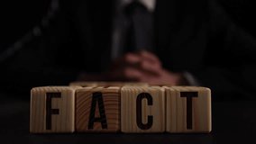 A man puts wooden blocks with the words Fact and fake. - Powered by Shutterstock - Get 15% off with code: PIKWIZARD15