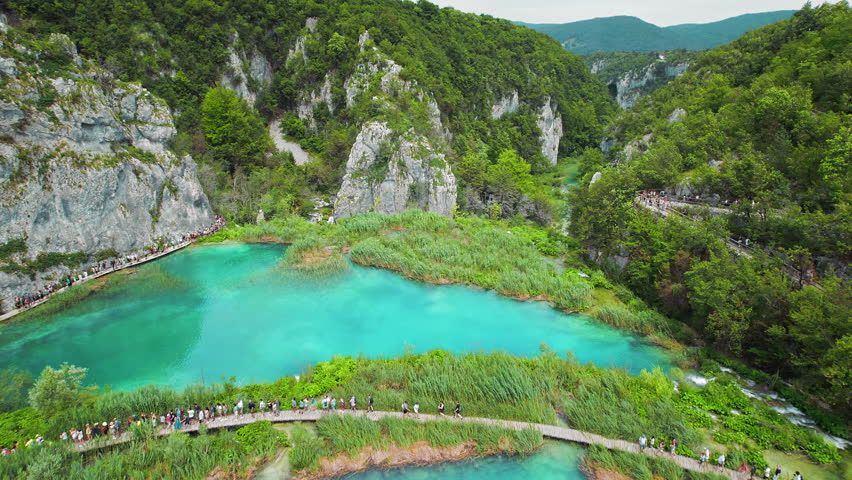 Hiking trail over mountain lake. Path for tourists in national park with waterfalls. Plitvice Lakes National Park Croatia.